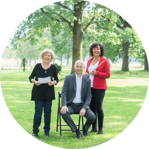 Drei Personen sind im Park vor einem Baum. Andreas Baumann (Piano) sitzt in der Mitte auf einem Stuhl, links steht Waltraud Falardeau (Text) und rechts daneben steht Sabine Burkhardt (Flöte).