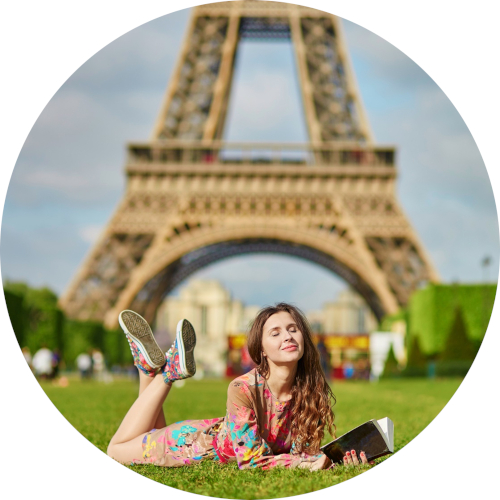 Frau auf Wiese liegend vor Eiffelturm.